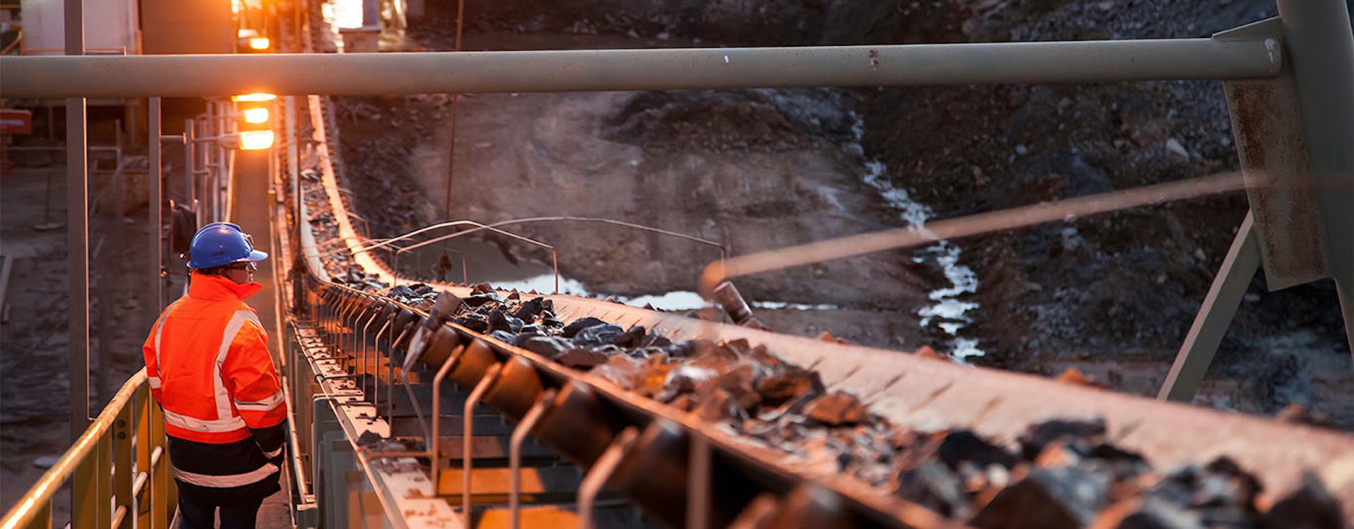 Nyngan Australia June 20th 2012 : Shallow depth of field image of a miner inspecting ore rocks on a conveyor in NSW Australia